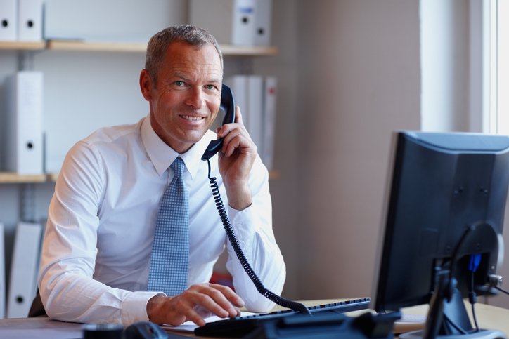 Businessman talking on the phone in front of a computer